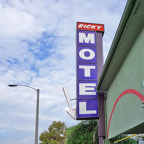 The image shows a street view with a tall vertical sign reading 